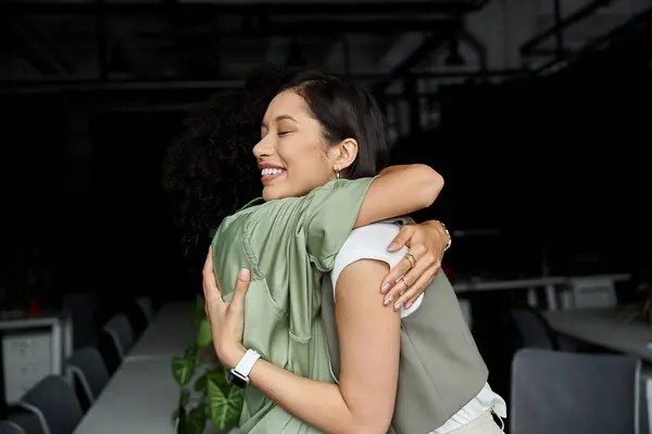 stock image Two women in an office setting embrace, showcasing a loving lesbian relationship.