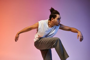 Genç bir Afrikalı Amerikalı, turuncu ve mor arka planda ifade ile dans ediyor..