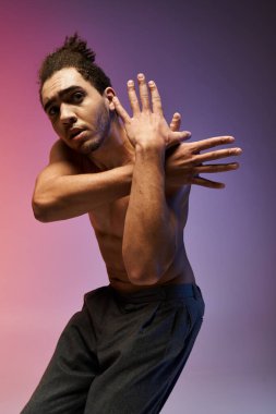 Dans eden genç bir Afrikalı Amerikalı, mor ve pembe bir arka plana karşı duruyor..