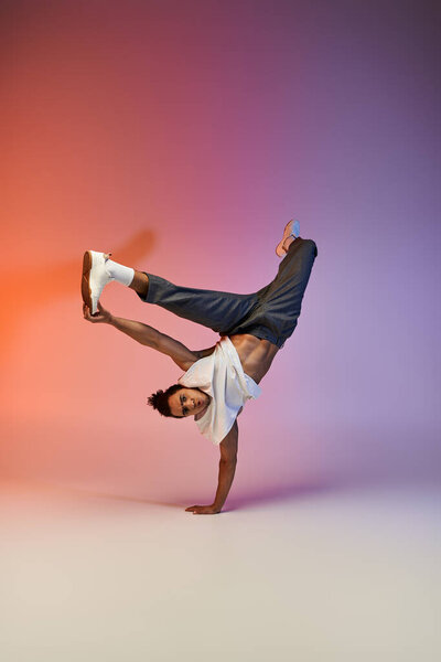A young African American man dances in a studio with a colorful gradient background.