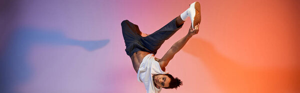 An African American young man dances against a vibrant gradient background, showcasing his acrobatic skills and energetic expression.
