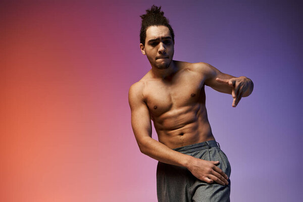 Молодой афроамериканец танцует на ярком, красочном градиентном фоне.