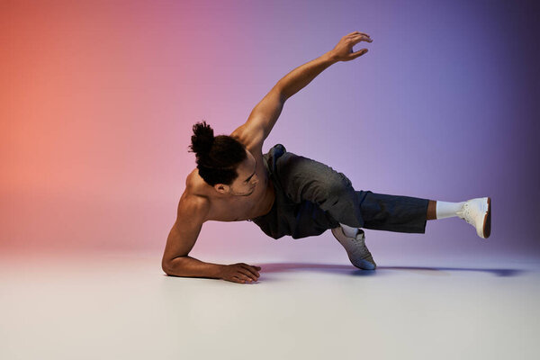 A young African American man dances on a gradient background of pink and purple.