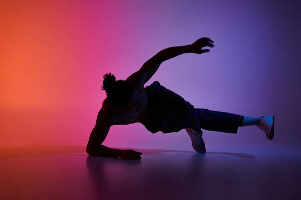A young African American man dances with passion against a colorful gradient background.