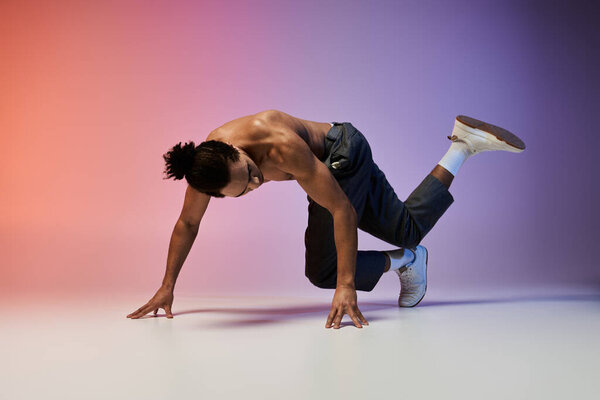 A young African American man performs a dynamic dance move against a colorful gradient background.