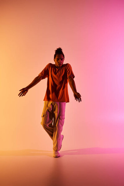 A young African American man dances on a vibrant gradient background.
