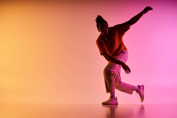 A young African American man dances in front of a vibrant, colorful gradient background.
