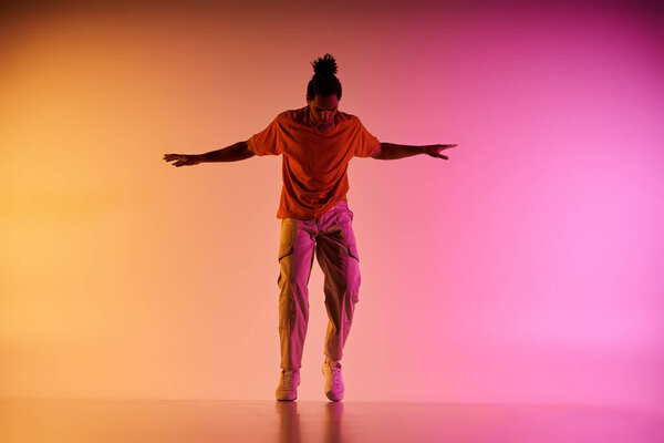 A young African American man dances energetically against a vibrant gradient background, embodying contemporary dance.
