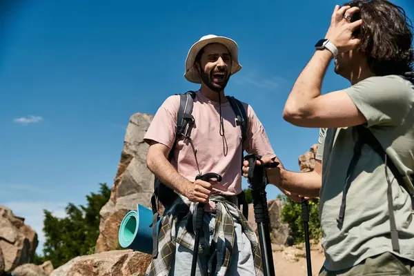 stock image Two young men, a gay couple, hike together in the summer wilderness, enjoying their time in nature.