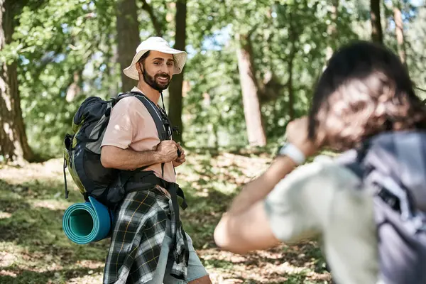 stock image A young gay couple hikes through a lush forest on a sunny summer day.