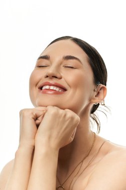 A smiling young brunette woman displays her luxurious jewelry on a white background, capturing the essence of beauty and grace. clipart