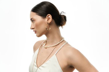 A young woman with dark hair showcases beautiful jewelry, including a pearl necklace and gold earrings, against a white backdrop. clipart