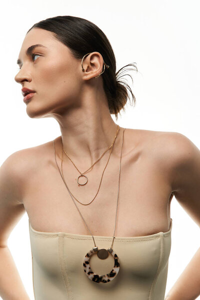 Молодая брюнетка с безупречным макияжем демонстрирует потрясающую коллекцию роскошных украшений на белом фоне.