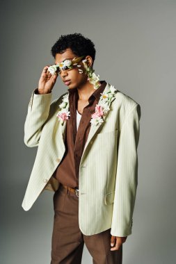Genç bir Afrikalı Amerikalı çiçek desenli yeşil bir ceketle poz veriyor. Güzellik ve çeşitlilik sergiliyor..