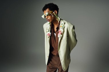 Genç bir Afrikalı Amerikalı, çiçeklerle süslenmiş şık bir ceketle poz veriyor..