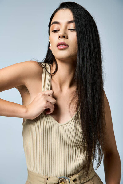 A young woman poses for the camera while adjusting her clothing.