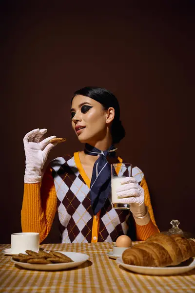 stock image A young woman, dressed in fashionable attire, enjoys a leisurely breakfast.