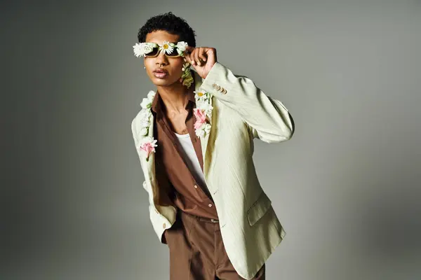 stock image A young African American man poses confidently in a stylish blazer, adorned with a floral garland and sunglasses.