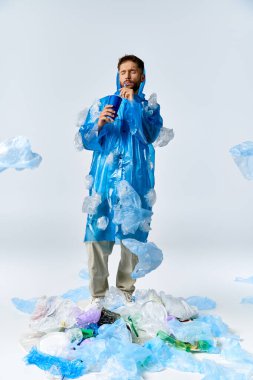 Plastik bir denizin ortasında duran bir adam, plastik torbalar ve şişelerle çevrili..