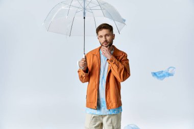 A man holds a clear umbrella with plastic bags floating around him. clipart