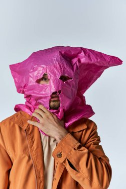 Kafasında plastik poşet olan bir adam, biraz rahatsız görünüyor..