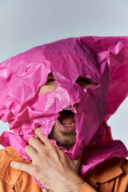 A man struggles to breathe, his face partially covered by a pink plastic bag. clipart