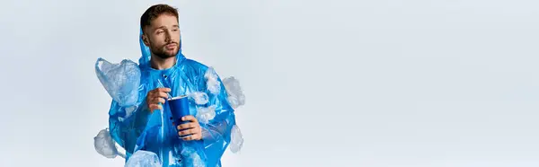 Stock image A man stands surrounded by plastic bags and debris.