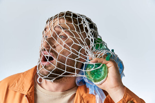 A man struggles with plastic waste, his face covered in a net.