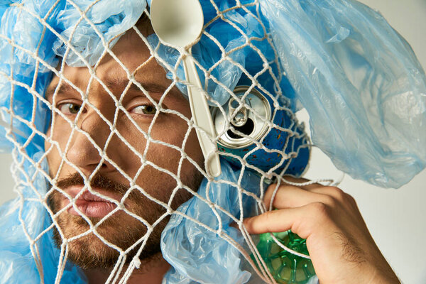 Mans face hidden by net and plastic bags, showing impact of plastic pollution.
