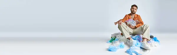 stock image A man sits surrounded by a sea of plastic bags, his expression thoughtful.