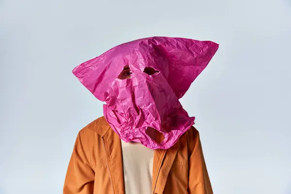 stock image A man wearing a pink plastic bag as a mask.