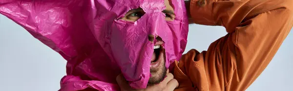 stock image A man's face is partially covered with a pink plastic sheet.