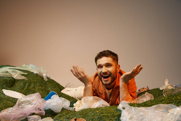 A smiling man lies surrounded by a sea of plastic.