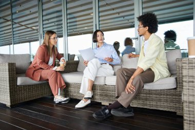 Modern bir ofis binasının çatısındaki terasta gelişigüzel sohbet eden üç iş arkadaşı. Bir meslektaşımın protez bacağı var..