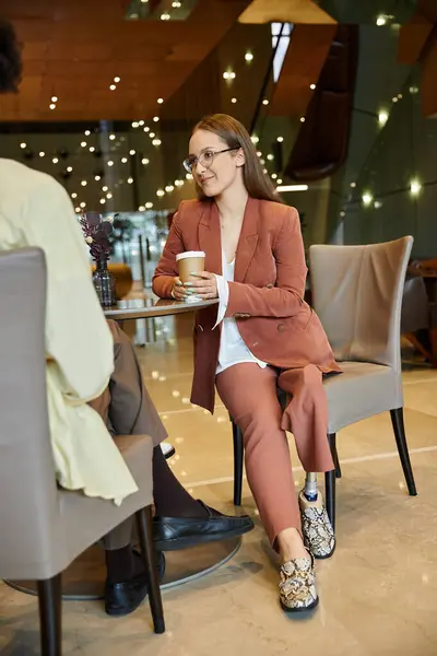 stock image Two colleagues chat in a modern office, enjoying a coffee break.