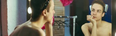Performansları için hazırlanan bir travesti sahne arkasında aynanın önünde duruyor..