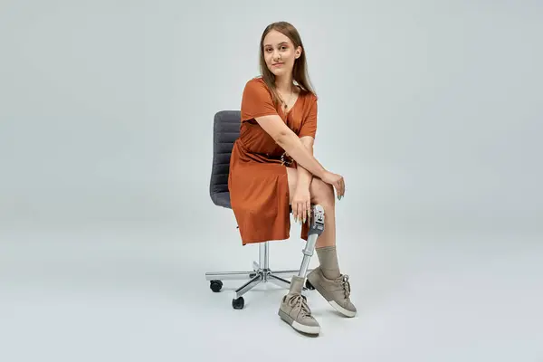 stock image Woman in brown dress smiles confidently at camera with visible prosthetic leg