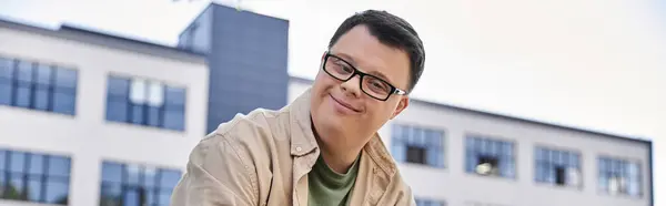 stock image A man with Down syndrome smiles as he walks past a building.