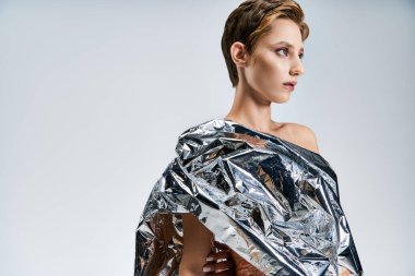 A woman models sustainable fashion made from recycled materials. clipart