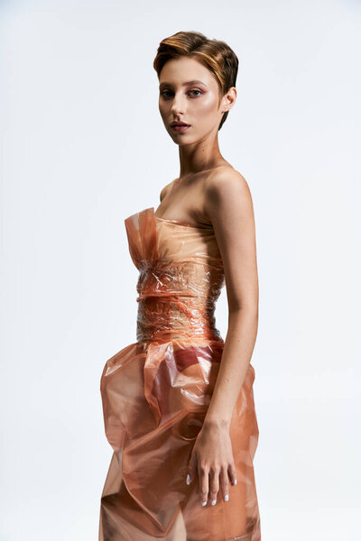 Женщина в платье полностью из пластиковых поз на белом фоне.