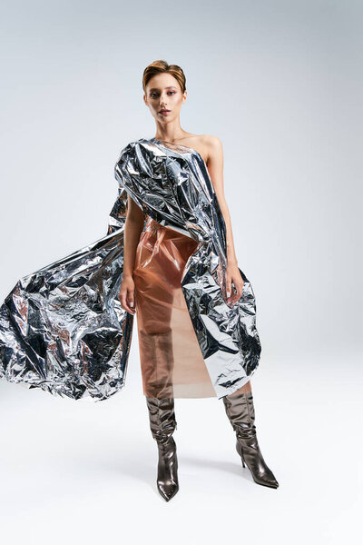 A woman poses in a studio wearing a sustainable fashion dress made from recycled materials.