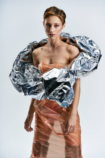 Женщина позирует в устойчивом создании моды из переработанных материалов.