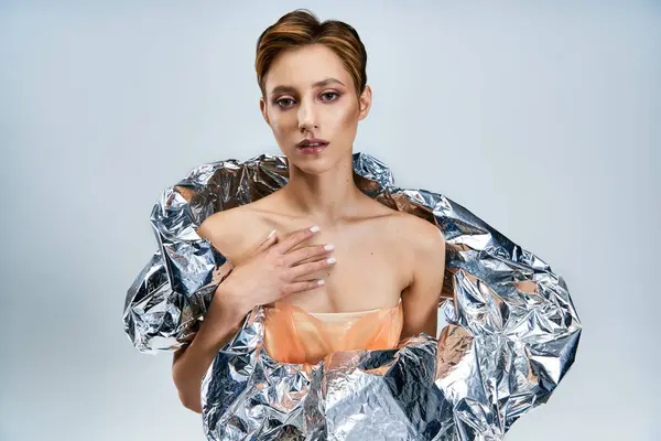 stock image A woman in a futuristic fashion design, draped in reflective material.