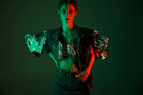 stock image A woman poses in sustainable fashion, illuminated by contrasting green and red lights.