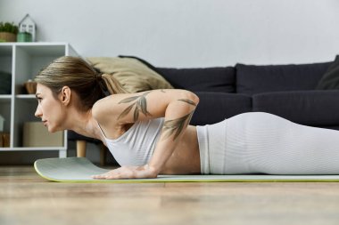 Vitiligo 'su olan genç bir kadın modern bir dairede yoga yapıyor. Nefes alıp verişine ve farkındalığına odaklanıyor..