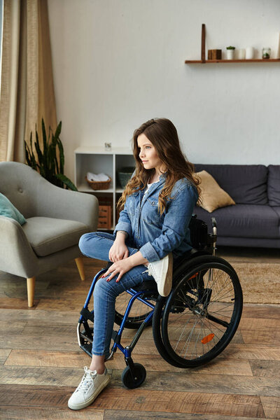 Молодая женщина сидит в инвалидной коляске в современной квартире с деревянными полами.