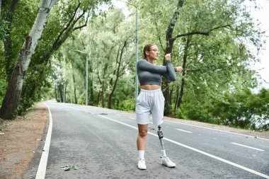 Spor giyim sektöründe genç bir kadın aktif olarak açık havada egzersiz yapıyor, azimle fitness 'i kucaklıyor..