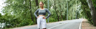 Protez bacaklı kararlı genç bir kadın spor kıyafetlerinde gücünü sergileyerek dışarıda spor yapmayı benimsiyor..