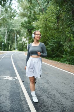 A young woman in sportswear confidently works out outdoors, embracing fitness and nature.