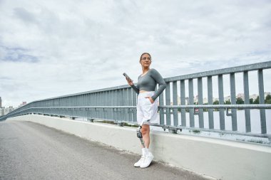 Spor kıyafetlerinde kararlı genç bir kadın dışarıda egzersiz yapıyor, gücünü ve dayanıklılığını kucaklıyor..